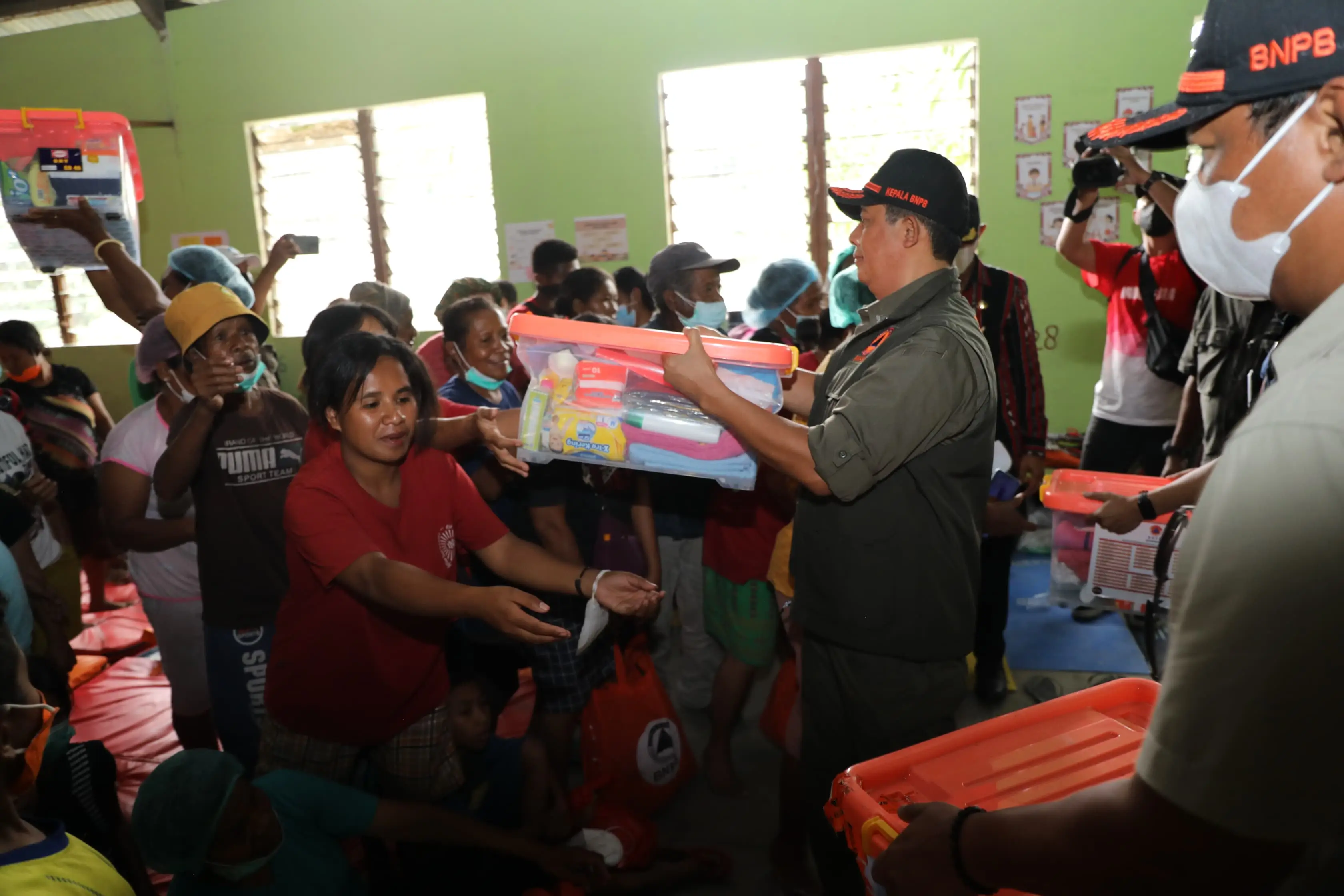 Kepala Badan Nasional Penanggulangan Bencana (BNPB) Letjen TNI Dr. Suharyanto, S.Sos., M.M (kemeja dan rompi hijau) saat memberikan bantuan kepada pengungsi yang berada di Desa Hikong, Kabupaten Sikka, Nusa Tenggara Timur pada Jumat (8/11).